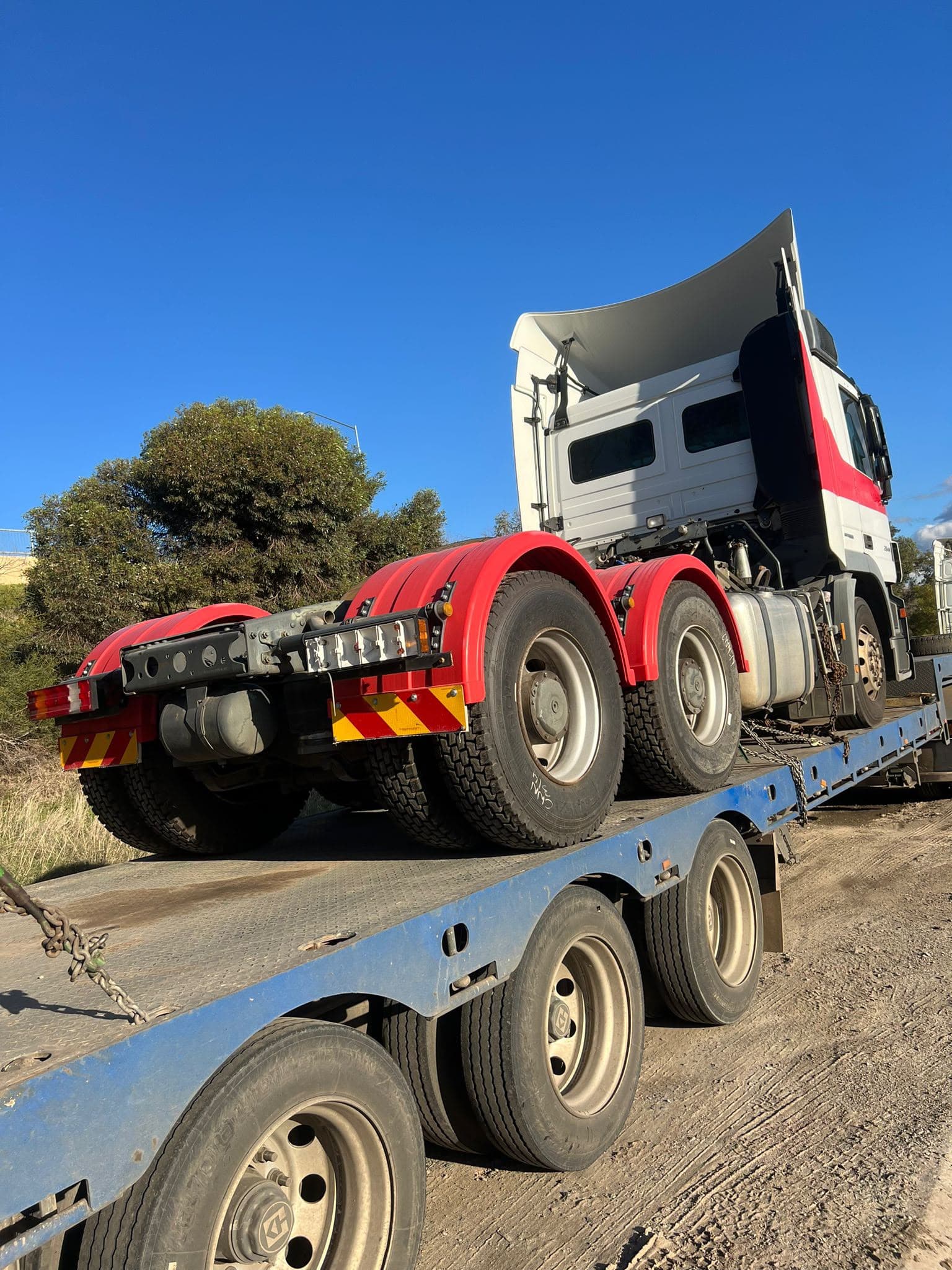 Rear view of a prime mover chained to a low loader