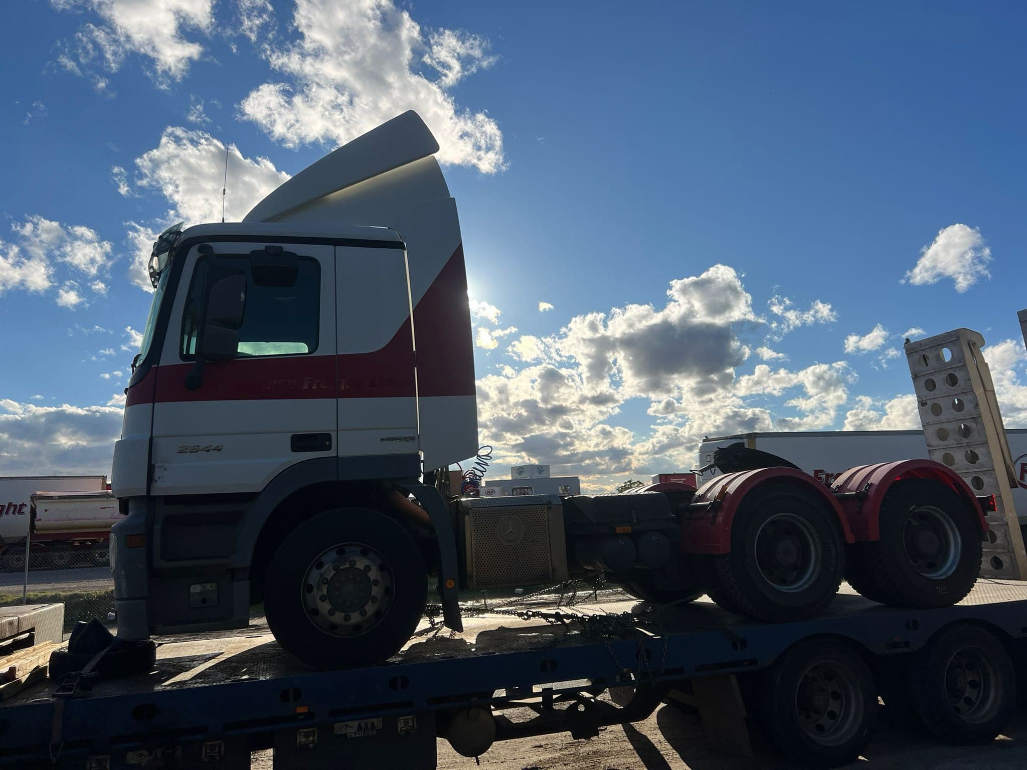 Prime mover on a low loader at dusk